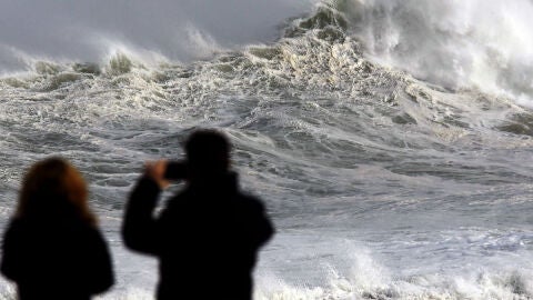 Dos personas fotograf&iacute;an el fuerte oleaje