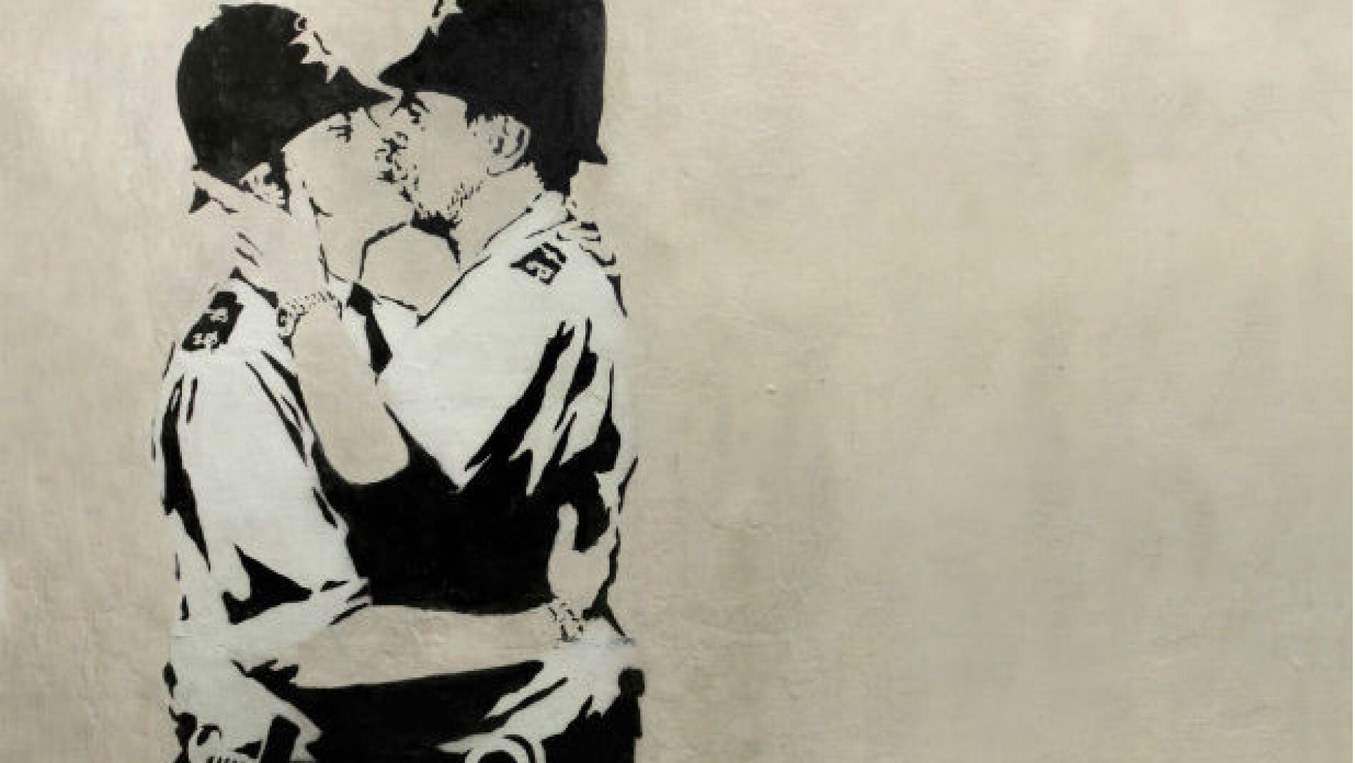 Obra de Banksy en blanco y negro, en la que aparecen dos polic&iacute;a brit&aacute;nicos bes&aacute;ndose.