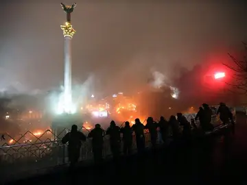 Policías antimotines permanecen junto a una barricada de manifestantes Policías antimotines permanecen junto a una barricada de manifestantes