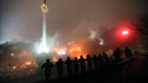Polic&iacute;as antimotines permanecen junto a una barricada de manifestantes