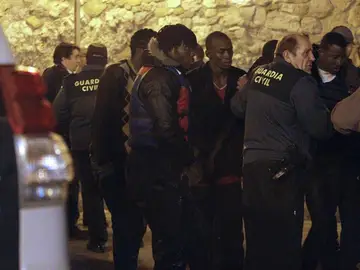 Miembros de la Guardia Civil atienden a algunos de los quince inmigrantes Miembros de la Guardia Civil atienden a algunos de los quince inmigrantes