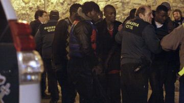 Miembros de la Guardia Civil atienden a algunos de los quince inmigrantes 