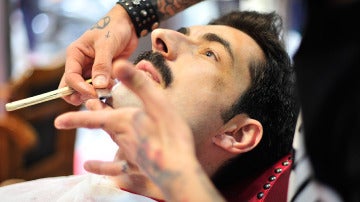 Un hombre afeitándose en una barbería