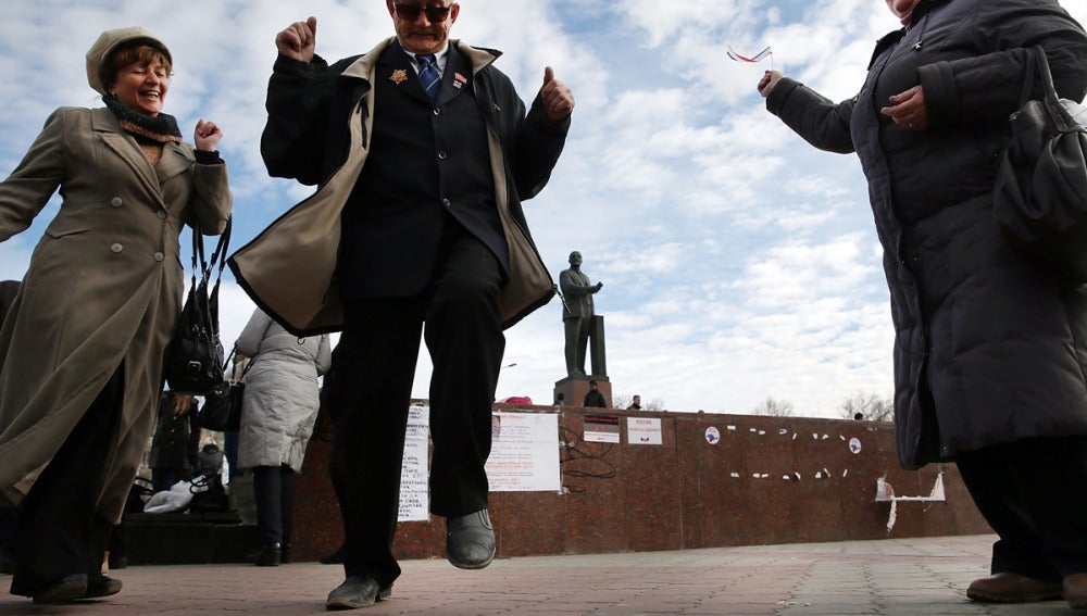 Dos personas afines a Moscú bailan en la plaza de Lenin