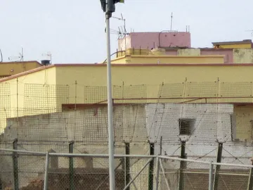 Un inmigrante subido en una farola de Melilla Un inmigrante subido en una farola de Melilla