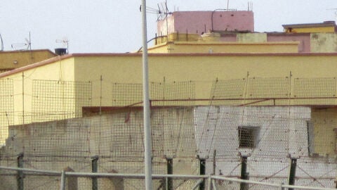 Un inmigrante subido en una farola de Melilla