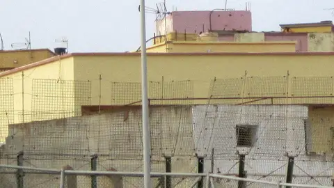 Un inmigrante subido en una farola de Melilla Un inmigrante subido en una farola de Melilla