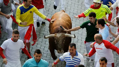 Dos mozos tocan a un toro durante un encierro de San Fermín Dos mozos tocan a un toro durante un encierro de San Fermín
