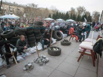 Un grupo de protestantes prorrusos permanecen cerca a una barricada