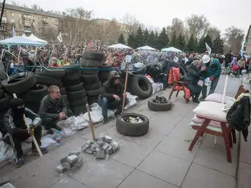 Un grupo de protestantes prorrusos permanecen cerca a una barricada Un grupo de protestantes prorrusos permanecen cerca a una barricada