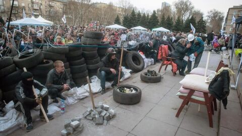 Un grupo de protestantes prorrusos permanecen cerca a una barricada
