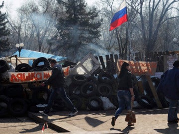 Ucranianos corren delante de una barricada