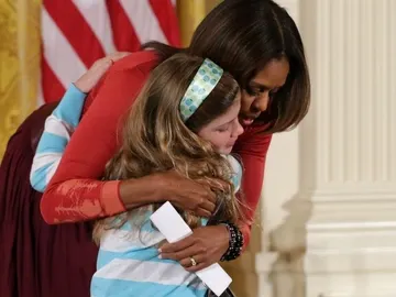 Michelle abraza a una niña de diez años en la Casa Blanca Michelle abraza a una niña de diez años en la Casa Blanca