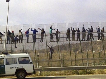Decenas de inmigrantes, encaramados en la valla de Melilla