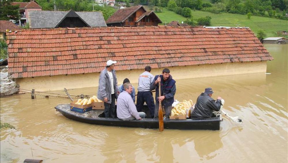 Unos residentes de la localidad serbia de Pozega recorren un calle inundada
