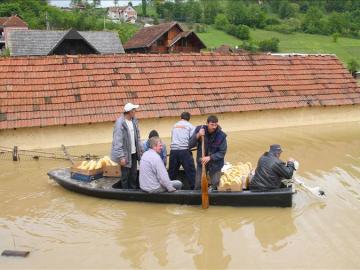 Unos residentes de la localidad serbia de Pozega recorren un calle inundada