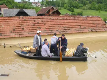 Unos residentes de la localidad serbia de Pozega recorren un calle inundada Unos residentes de la localidad serbia de Pozega recorren un calle inundada