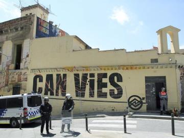 Agentes vigilan el acceso al inmueble Can Vies, en Barcelona