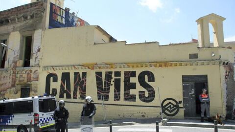 Agentes vigilan el acceso al inmueble Can Vies, en Barcelona