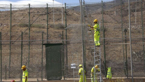 Un grupo de operarios repara el tramo de valla por donde han saltado m&aacute;s de 500 inmigrantes