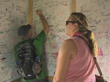 Dos turistas dejan su firma en la tela rígida instalada en la Gran Muralla china
