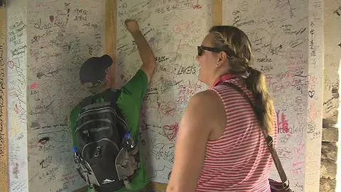 Dos turistas dejan su firma en la tela rígida instalada en la Gran Muralla china Dos turistas dejan su firma en la tela rígida instalada en la Gran Muralla china