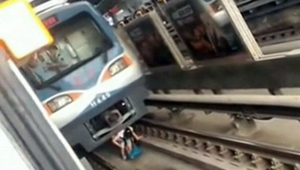 Una mujer embrazada sale de debajo de un tren en Pekín