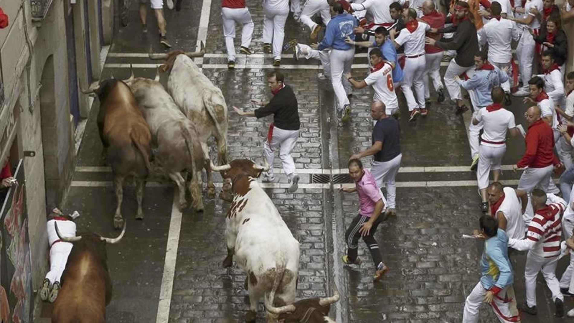 Los mozos corren delante de los toros de la ganadería de Fuente Ymbro durante el sexto encierro