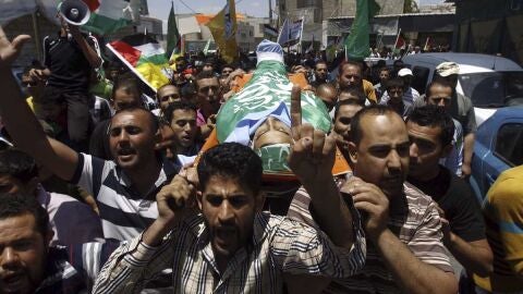 Varios palestinos trasladan un cad&aacute;ver
