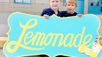 Dos pequeños venden limonada para recaudar dinero
