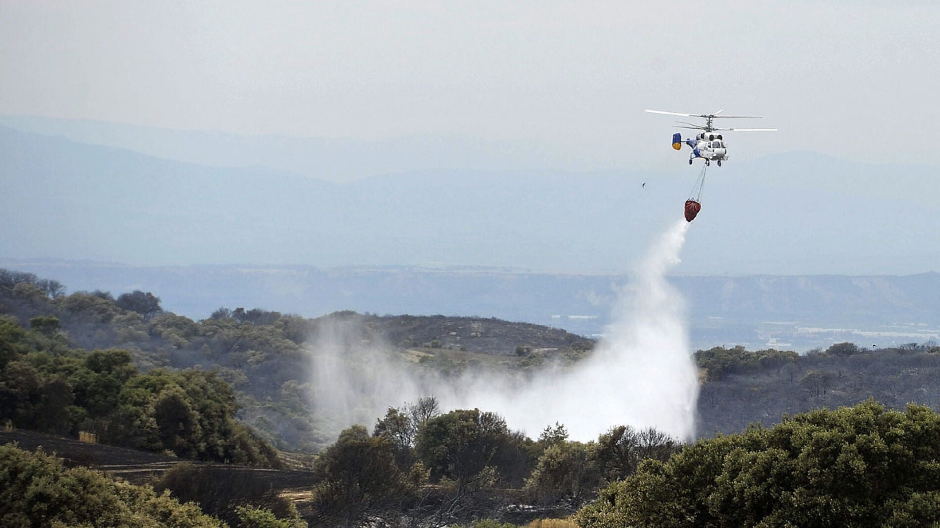 Un helic&oacute;ptero colabora en las tareas de extinci&oacute;n.