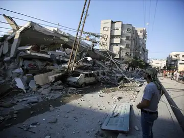 Unos palestinos observan un edificio destruído por proyectiles en Gaza Unos palestinos observan un edificio destruído por proyectiles en Gaza
