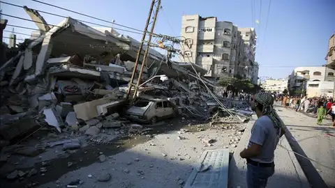 Unos palestinos observan un edificio destruído por proyectiles en Gaza Unos palestinos observan un edificio destruído por proyectiles en Gaza