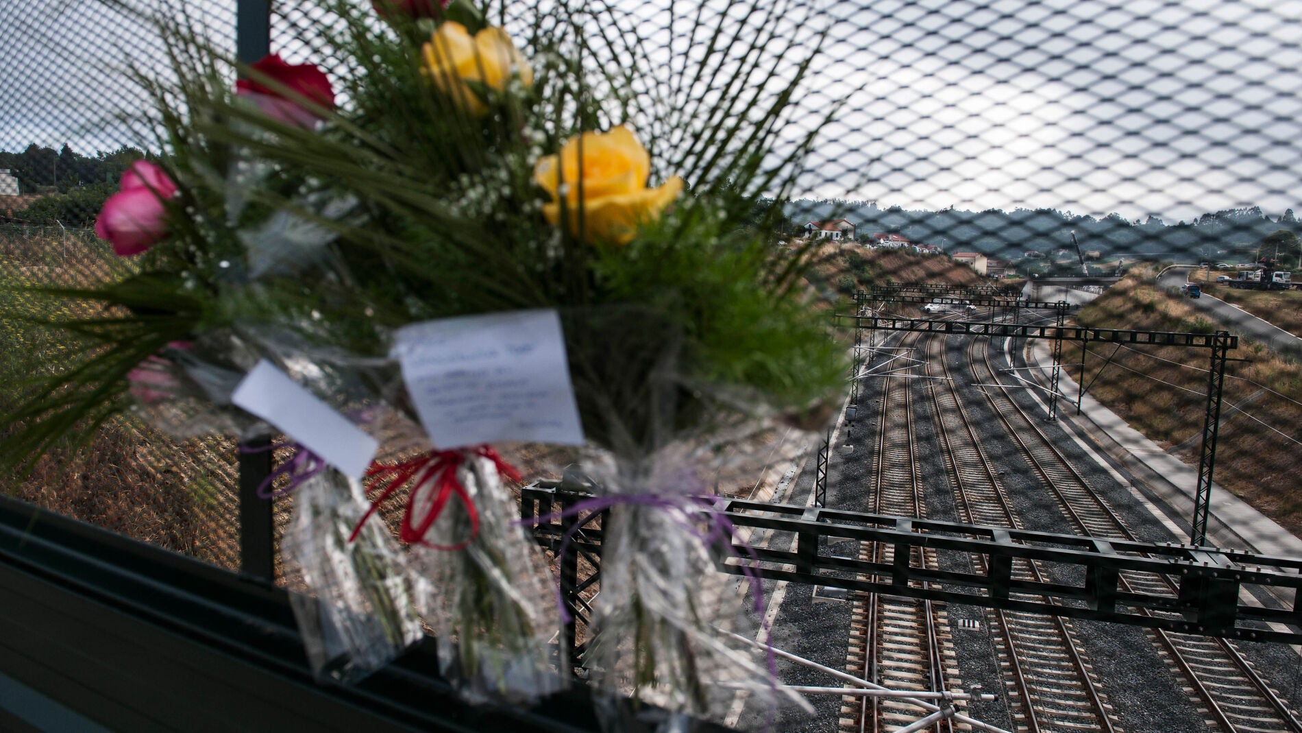 En la verja que da a la curva de A Grandeira se agolpan flores en recuerdo de las v&iacute;ctimas
