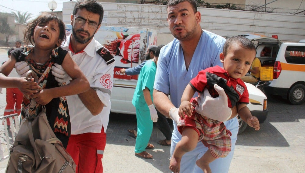 Palestinos llevan a unos niños heridos en brazos a un hospital 