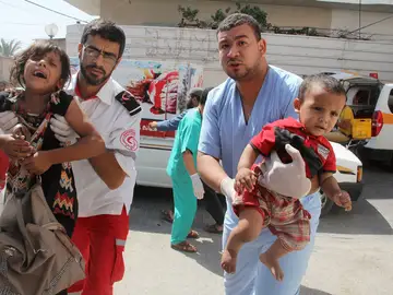 Palestinos llevan a unos niños heridos en brazos a un hospital Palestinos llevan a unos niños heridos en brazos a un hospital