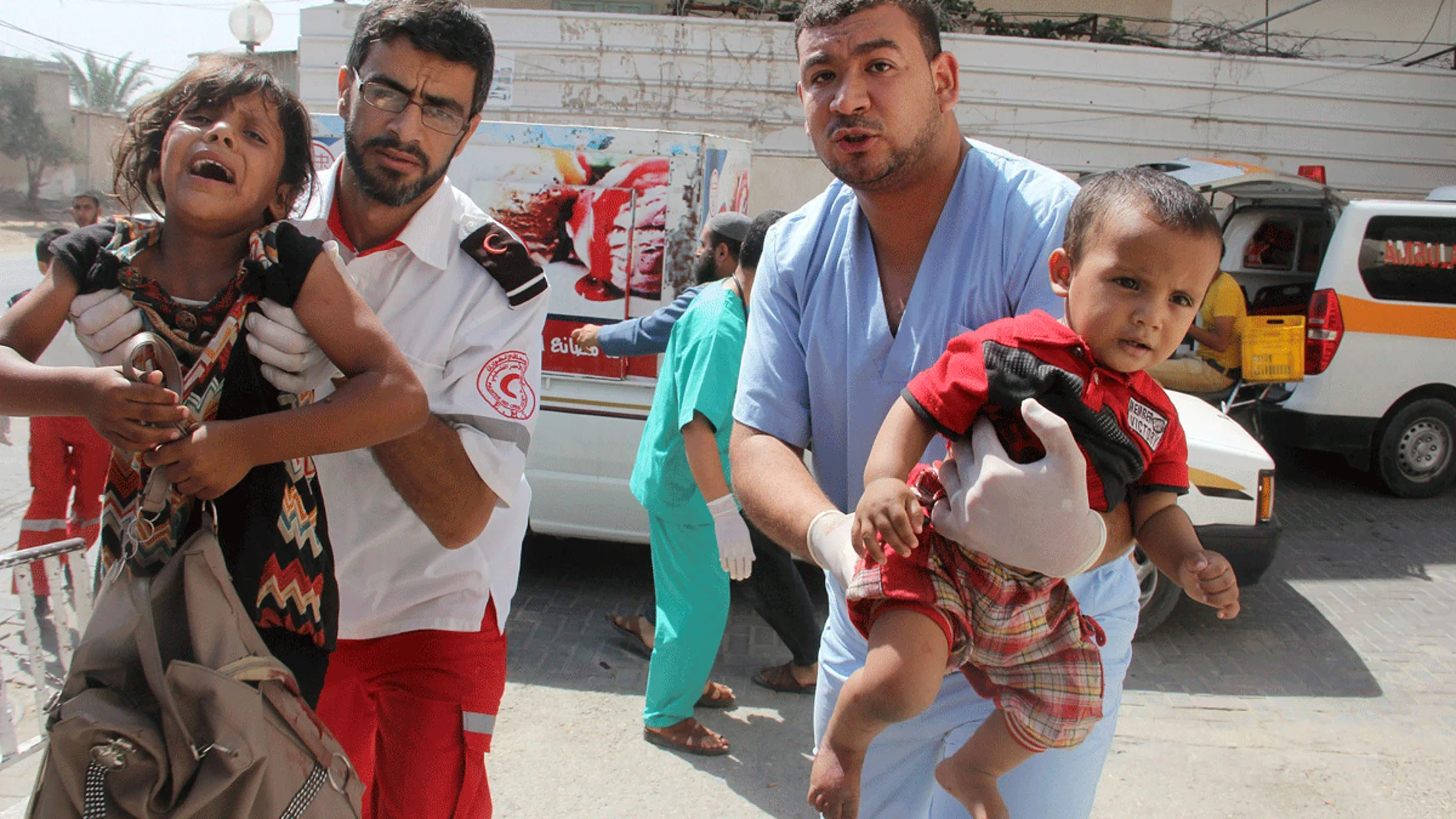 Palestinos llevan a unos niños heridos en brazos a un hospital Palestinos llevan a unos niños heridos en brazos a un hospital