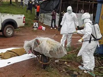 Varias enfermeras desinfectan una víctima del ébola en la calle Varias enfermeras desinfectan una víctima del ébola en la calle