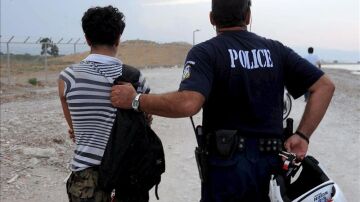 un policía griego con un inmigrante ilegal en la localidad de Kandare