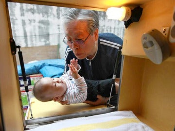El pastor de la Iglesia Lee Jong-rak, recogiendo a un bebé de la caja