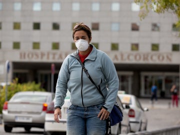 Una mujer lleva una máscara para protegerse de posibles contagios