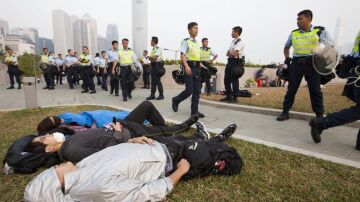 Activistas prodemocráticos descansan ante las autoridades.