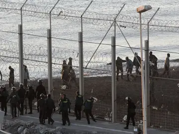 Las fuerzas españolas de seguridad e inmigrantes a ambos lado de la valla de Ceuta Las fuerzas españolas de seguridad e inmigrantes a ambos lado de la valla de Ceuta