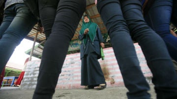 Una policía indonesia reprende a un grupo de mujeres