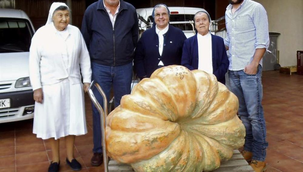 El agricultor posa con la calabaza y los gestores del Banco de Alimentos