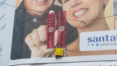 Un hombre se cuelga de La Pedrera con pancartas comparando el aborto con el nazismo