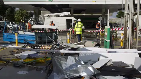 Empleados de una gasolinera retiran los desperfectos causados tras los fuertes vientos Empleados de una gasolinera retiran los desperfectos causados tras los fuertes vientos