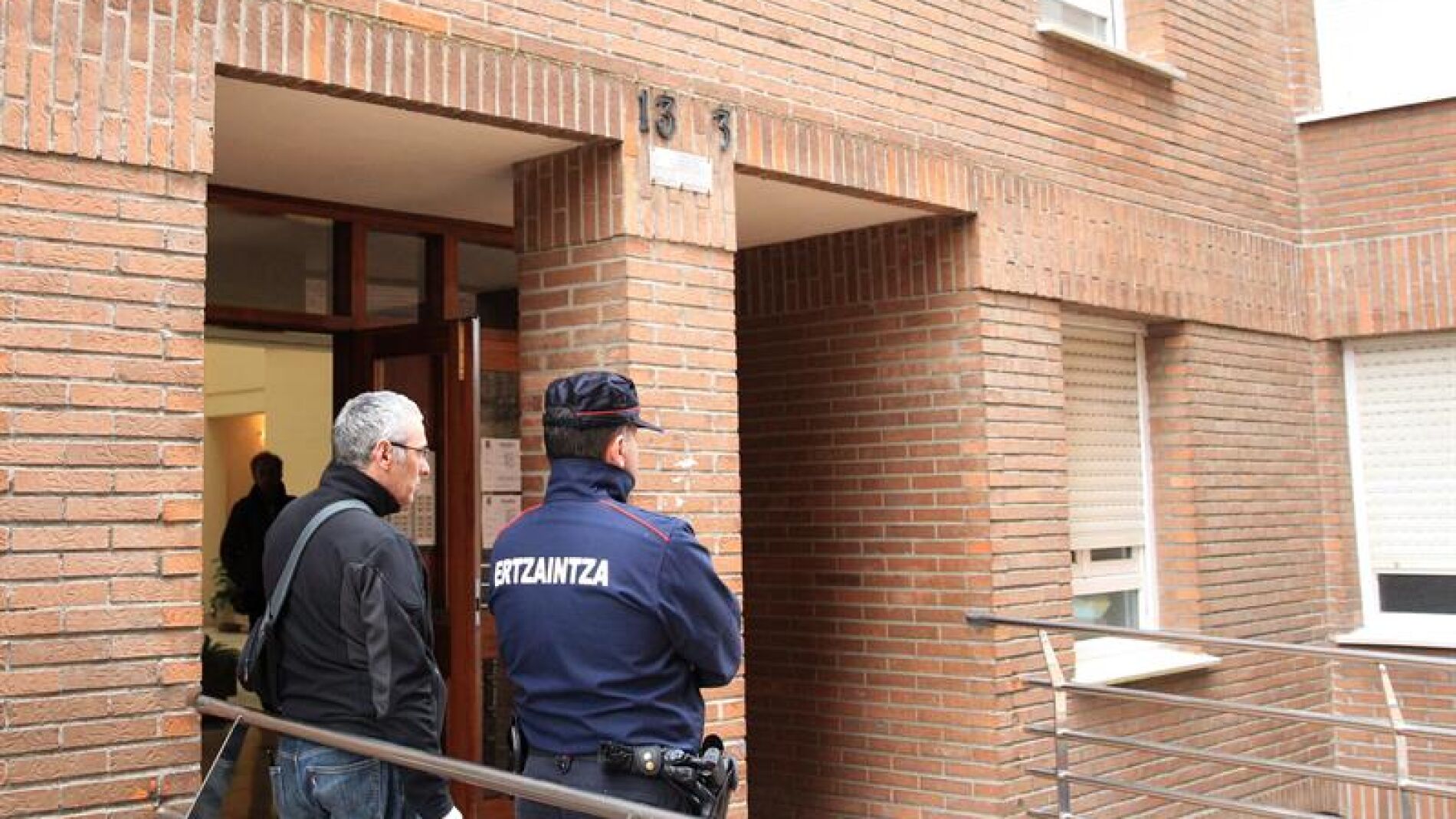 Agentes de la Ertzaintza en el portal de la vivienda de la localidad vizca&iacute;na de Abadi&ntilde;o.