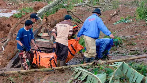 Varias personas trasportan un fallecido en Java Varias personas trasportan un fallecido en Java