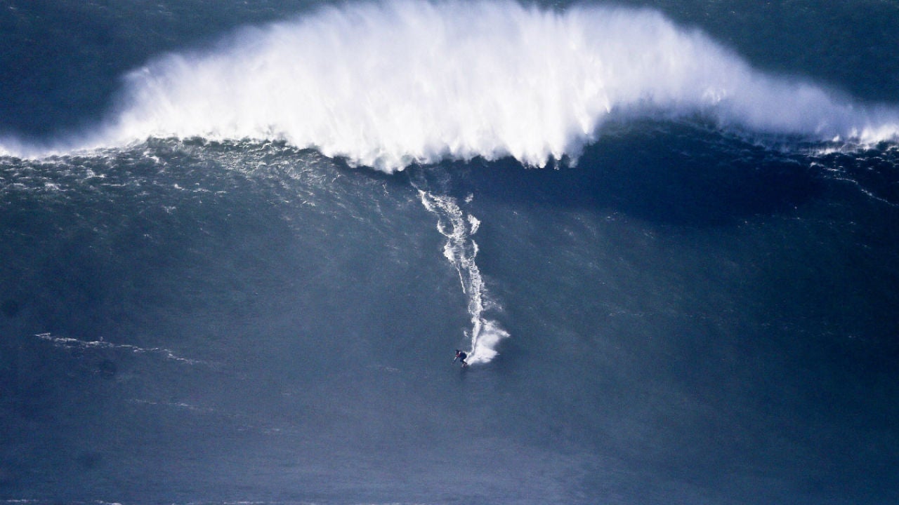 Los surfistas buscan en una playa portuguesa de Nazaré la ola más